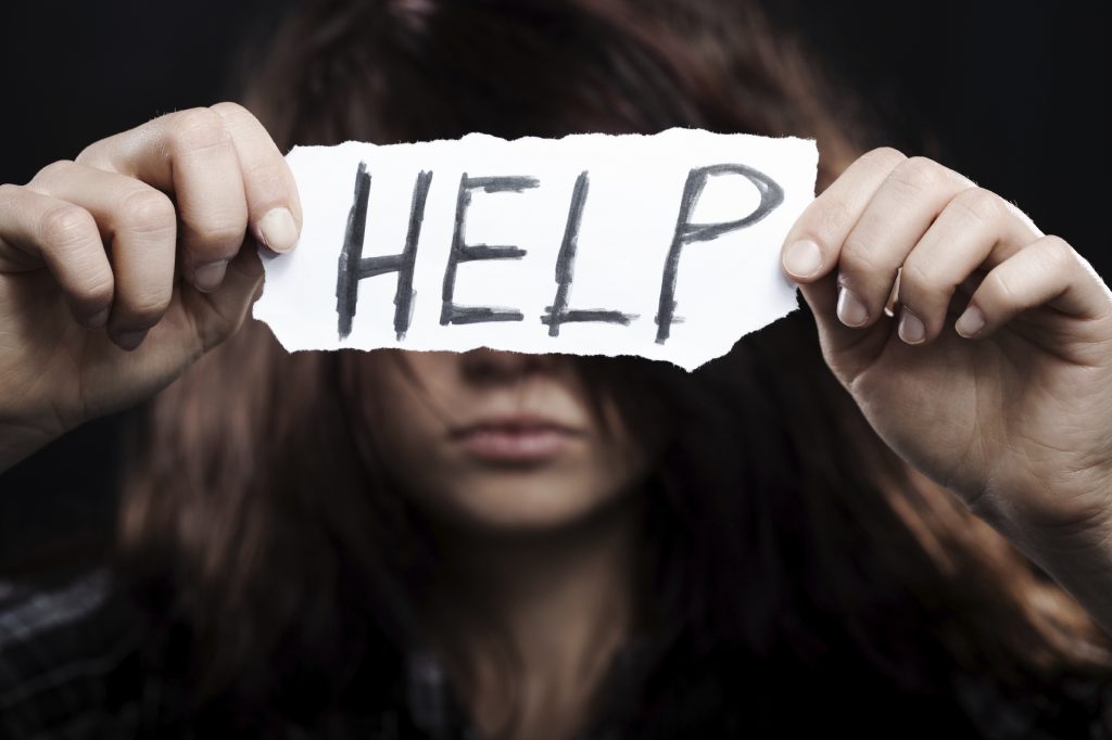 woman holding help sign up - holistic addiction treatment concept