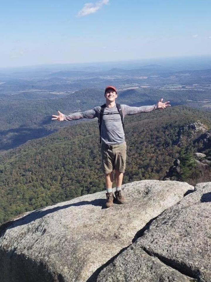 man standing on peak - benefits of structured sober living